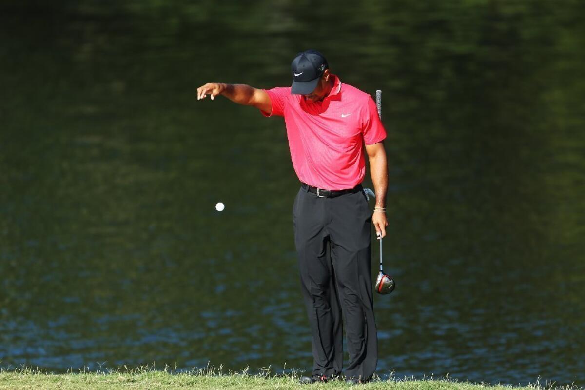 Tiger Woods takes his drop on the 14th hole Sunday.