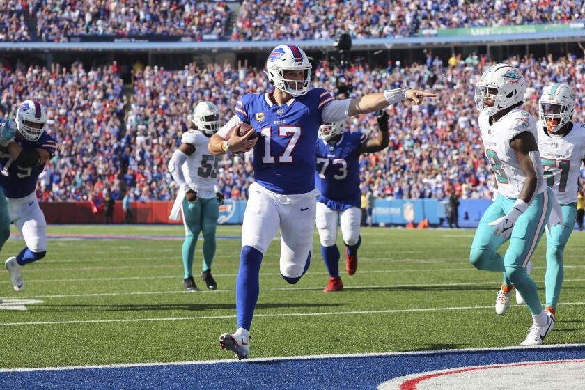 Buffalo Bills quarterback Josh Allen (17) runs into the end zone for a touchdown in front of Miami Dolphins safety Jevon Holland during the second half of an NFL football game, Sunday, Oct. 1, 2023, in Orchard Park, N.Y. (AP Photo/Jeffrey T. Barnes)