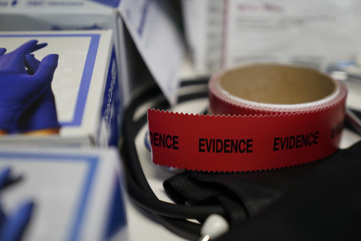 Evidence tape is seen with a Sexual Assault Evidence Collection Kit in an examination room.