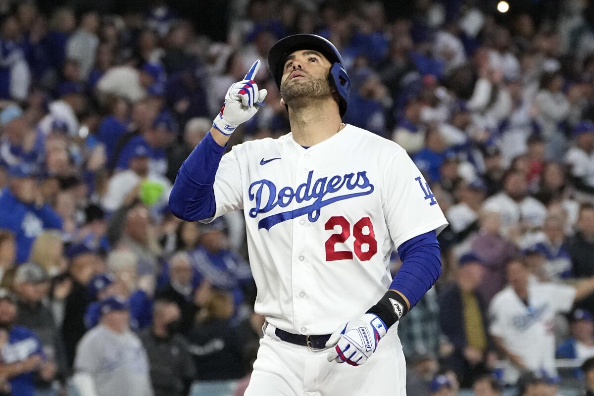 Los Angeles Dodgers' J.D. Martinez gestures as he scores after hitting a two-run home run.