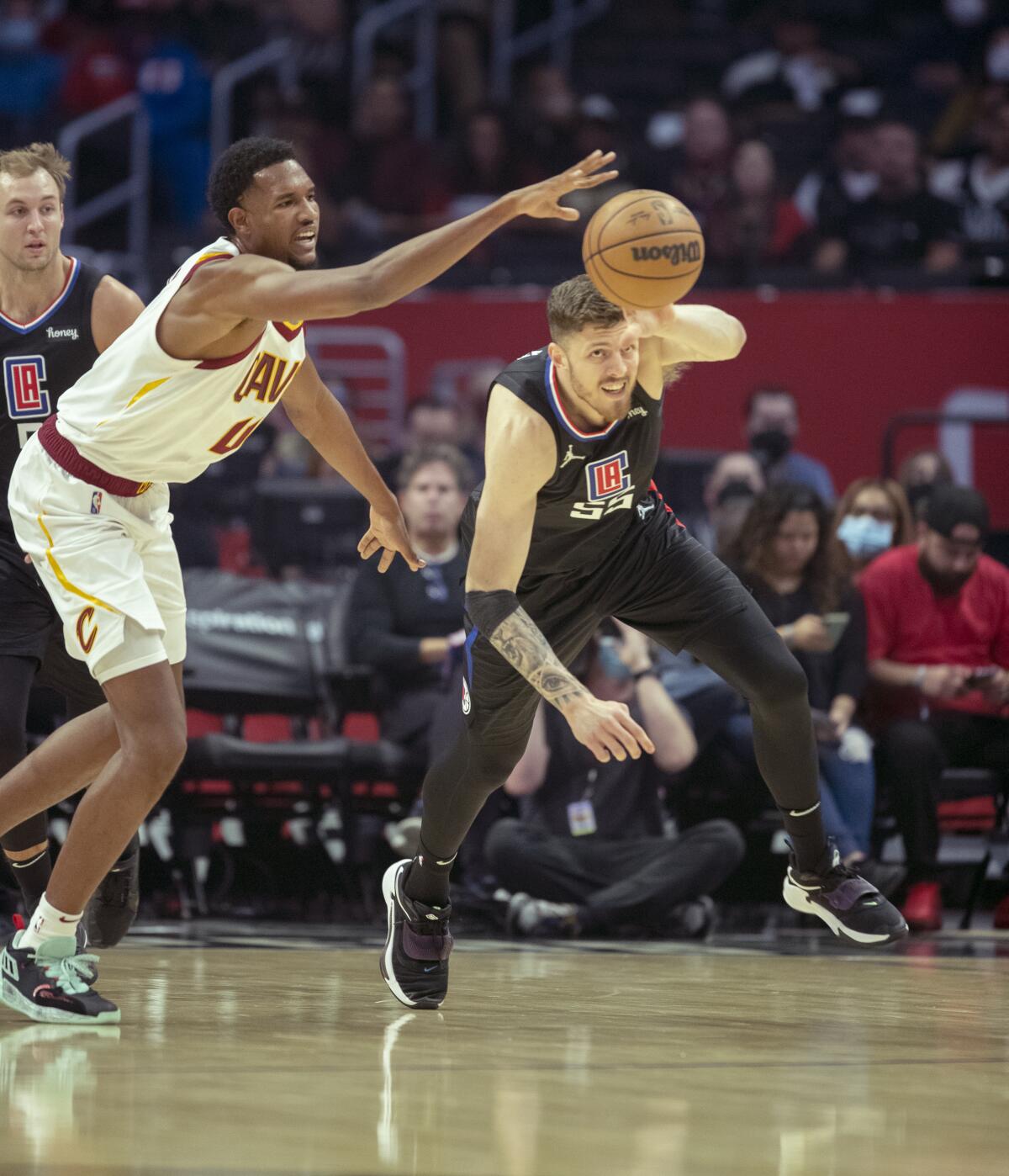 Cleveland Cavaliers center Evan Mobley battles Clippers center Isaiah Hartenstein for control of a loose ball.