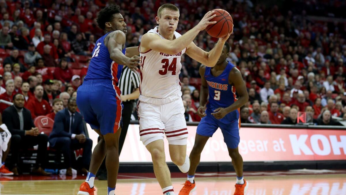 Brad Davison of the Wisconsin Badgers drives while being guarded by Jaquan Dotson of the Savannah State Tigers in the first half.