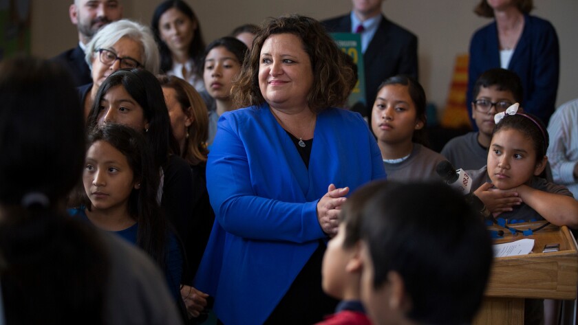 Myrna Castrejón, center, stands with schoolchildren at a June event unveiling plans by her group, Great Public Schools Now, to start new schools in Los Angeles.