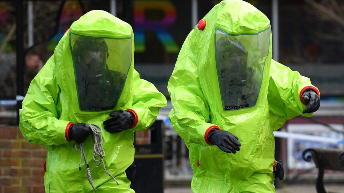 Members of the emergency services wear green biohazard suits as the investigate area when a former Russian spy and his daughter were found last month.