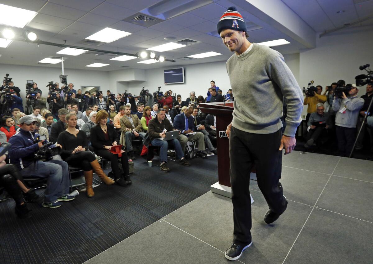 Patriots quarterback Tom Brady smirks as he steps away from a news conference in January.