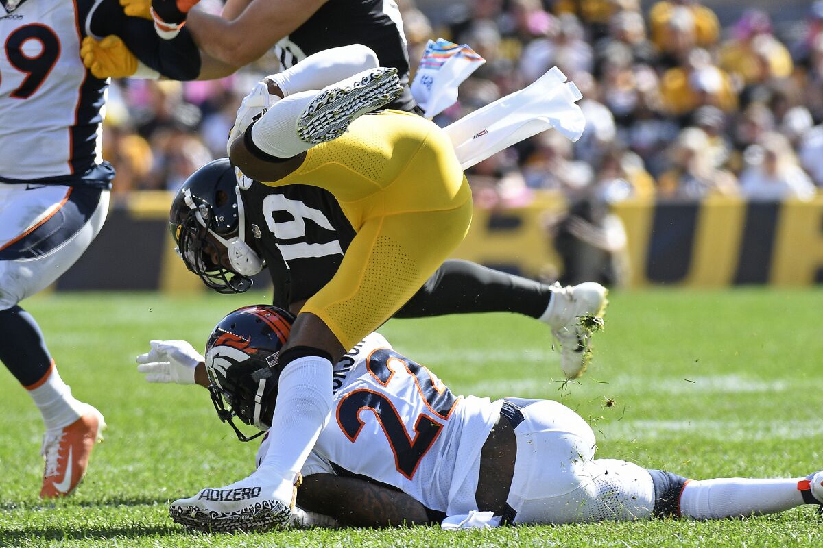 Pittsburgh Steelers wide receiver JuJu Smith-Schuster (19) is upended by Denver Broncos safety Kareem Jackson (22) during the first half of an NFL football game in Pittsburgh, Sunday, Oct. 10, 2021. Smith-Shuster was injured on the play and left the field. (AP Photo/Don Wright)