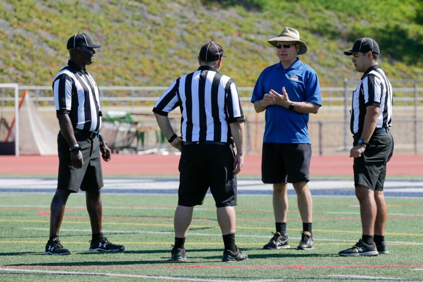 mike Weseloh of the Football Officials Association speaks to referees LD Wills, Ben Botton and Giovanni Ferrer during a break in the football action at Saturday's passing tournament