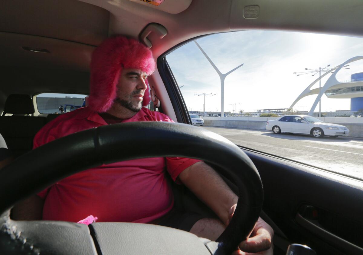 Lyft driver Carlos Van Deusen gets into the spirit of the first day of service at LAX by wearing a furry pink hat.