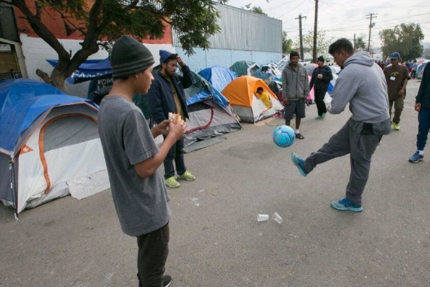 TIJUANA, BAJA CA. DEC 14, 2018,-Central Americans migrants played with a soccer ball in the street outside of the now shuttered Benito Juarez shelter in the Zona Norte. A new shelter, called "Comunidad contra viento y marea" which translates to "Community against wind and tides" has opened nearby. It will serve up to 600 people. PHOTO/JOHN GIBBINS Staff photographer, San Diego Union-Tribune. ©2018