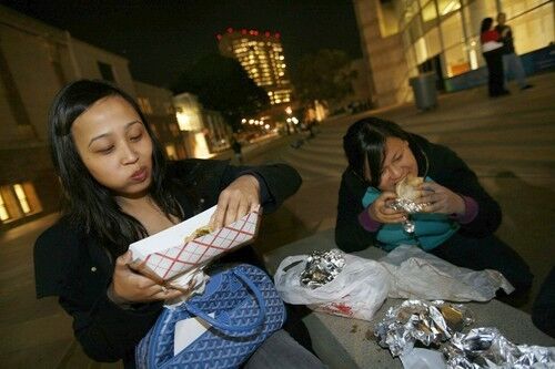 Carla Brizuela and Leilani Bermajo enjoy their tacos on the steps of the Japanese American National Museum in Little Tokyo.