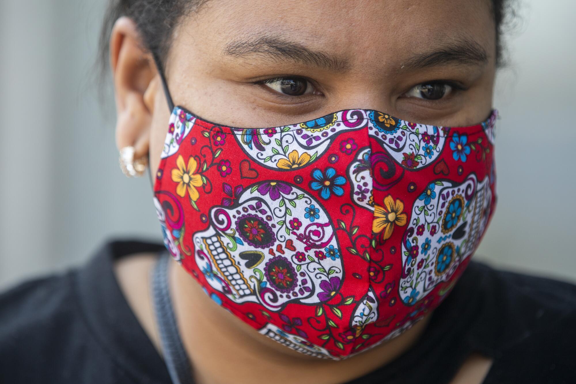 A woman wears a Day of the Dead-style face mask 