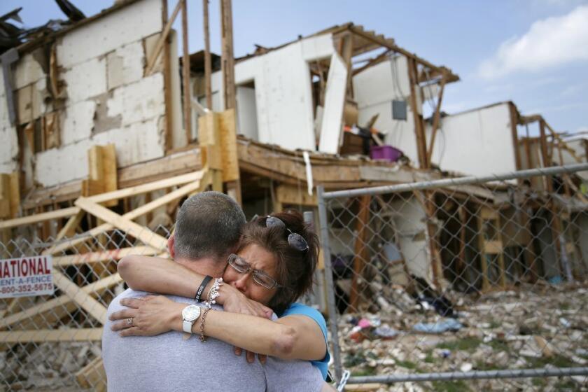 Shona Jupe, a resident of the apartment destroyed by the fertilizer plant explosion, hugs her friend as they met while she was visiting the site in West, Texas. Jupe was at the front door when the West Fertilizer Co. explosion happened.