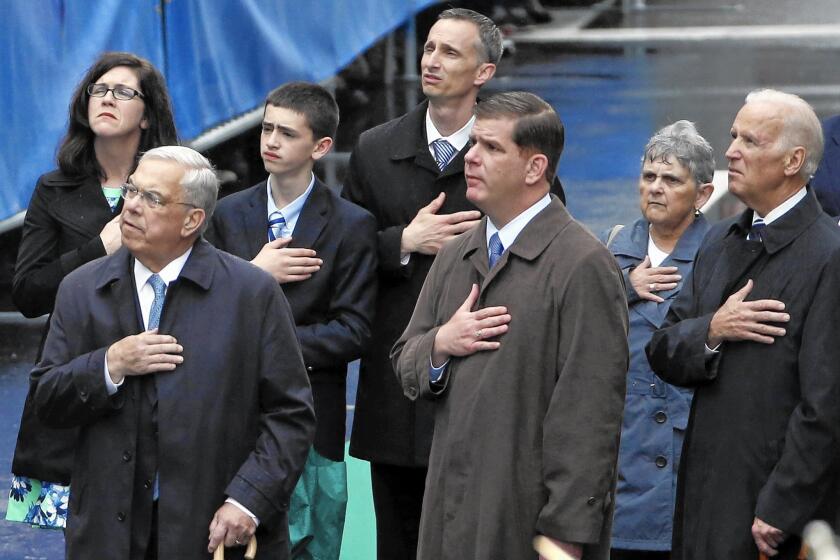 Former Boston Mayor Thomas Menino, left, Boston Mayor Marty Walsh and Vice President Joe Biden attend a remembrance ceremony at the 2014 Boston Marathon's finish line. Menino, who led the city through the aftermath of the 2013 bombings, died Thursday. He was 71.