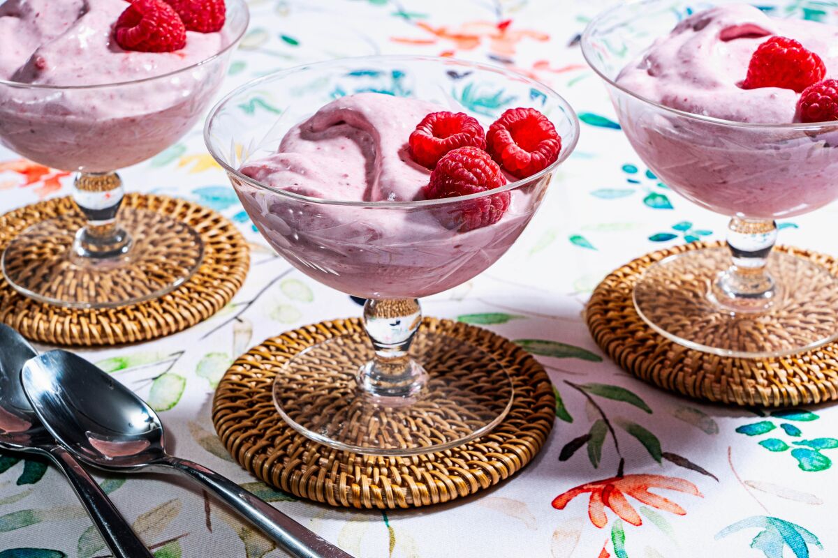 Pink strawberry fool is topped with raspberries.