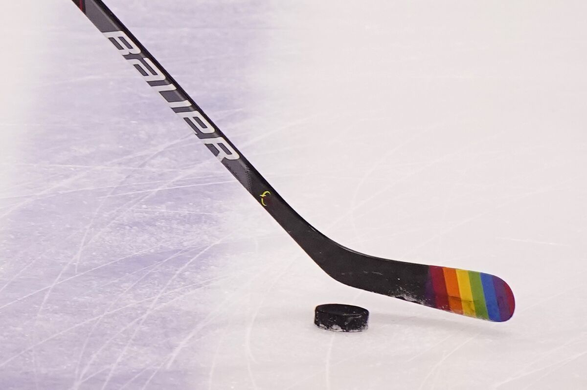 FILE - Florida Panthers center Eetu Luostarinen uses a stick with the LGBT pride flag on it before the start of an NHL hockey game against the Nashville Predators during Pride Day, Saturday, March 20, 2021, in Sunrise, Fla. The Chicago Blackhawks will not wear Pride-themed warmup jerseys before Sunday's Pride Night game against Vancouver because of security concerns involving a Russian law that expands restrictions on activities seen as promoting LGBTQ rights in the country. (AP Photo/Wilfredo Lee, File)