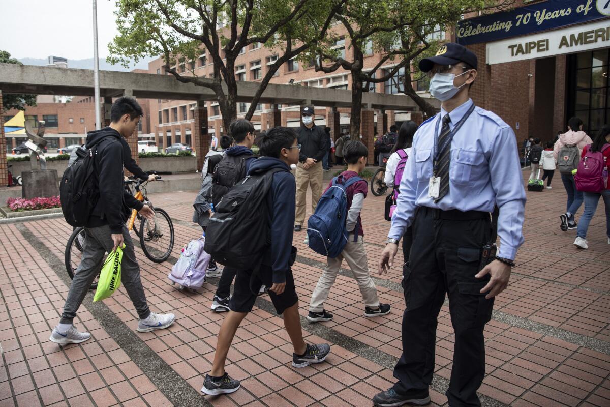 Students enter Taipei American School in Taiwan on Wednesday.
