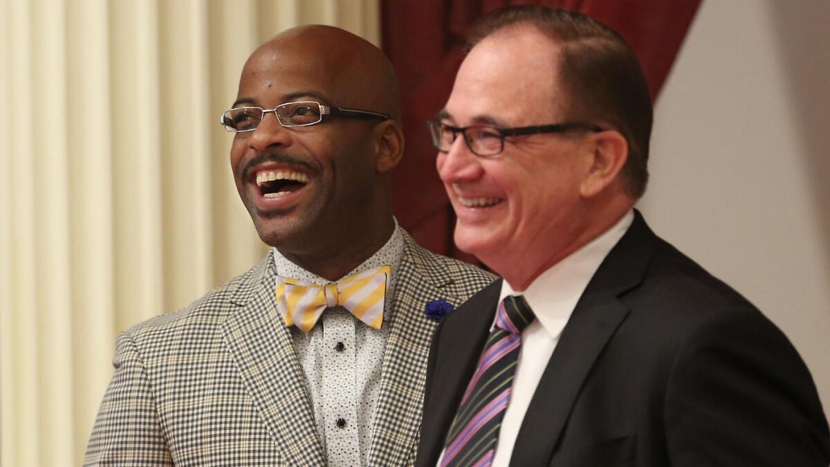 Assemblyman Isadore Hall (D-Compton), left, and Senate Minority Leader Robert Huff (R-Diamond Bar) smile as Hall's measure seeking to ban California from selling or displaying items with the Confederate flag was approved by the Senate on Monday.