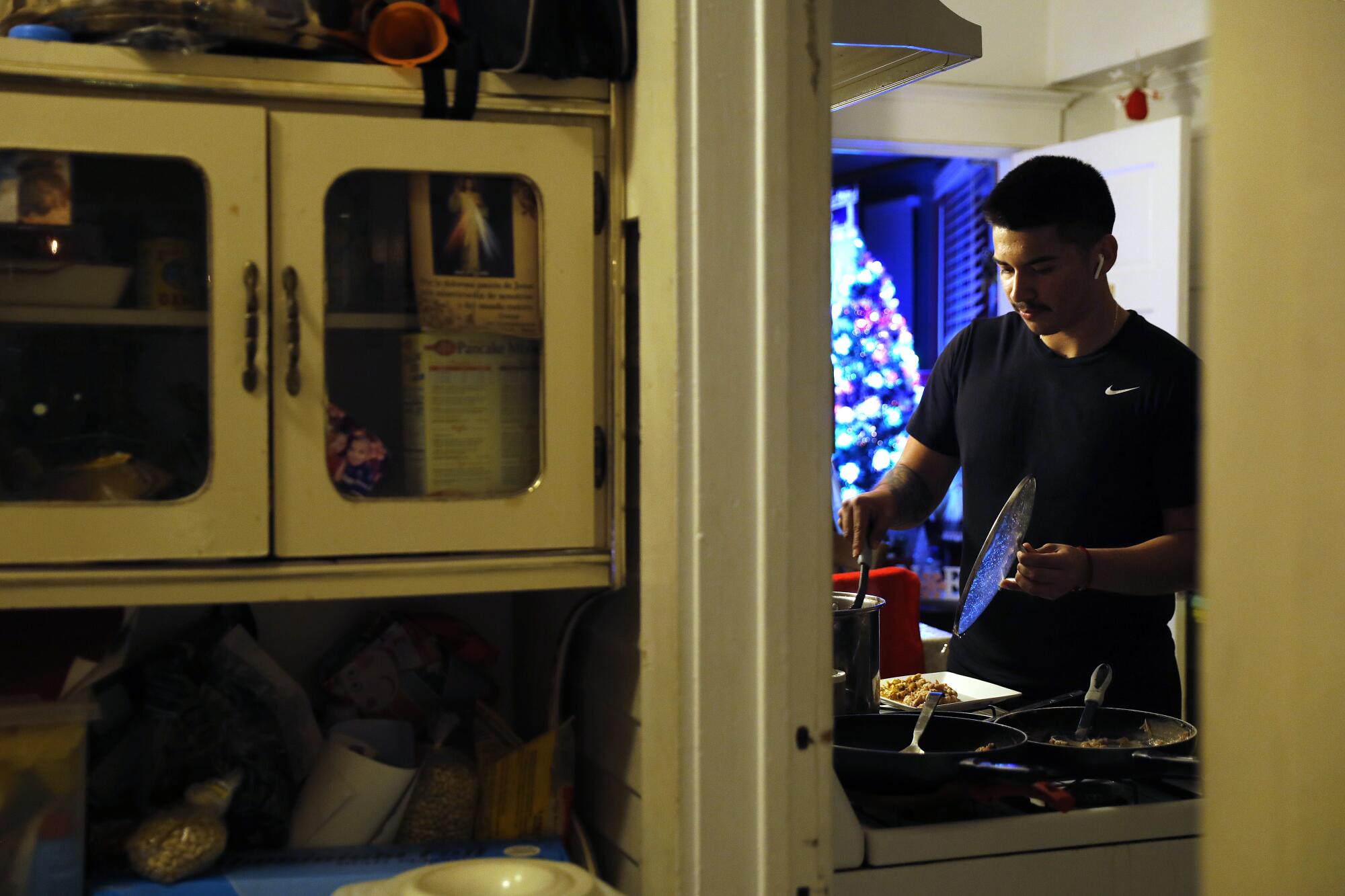 Roosevelt quarterback Damian Avalos makes dinner at home in Boyle Heights after a day of training.