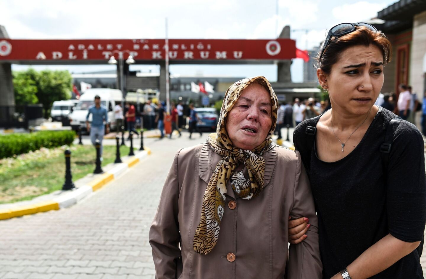 A woman assists a mother who lost a relative, outside a forensic medicine building close to Istanbul's airport on June 29.