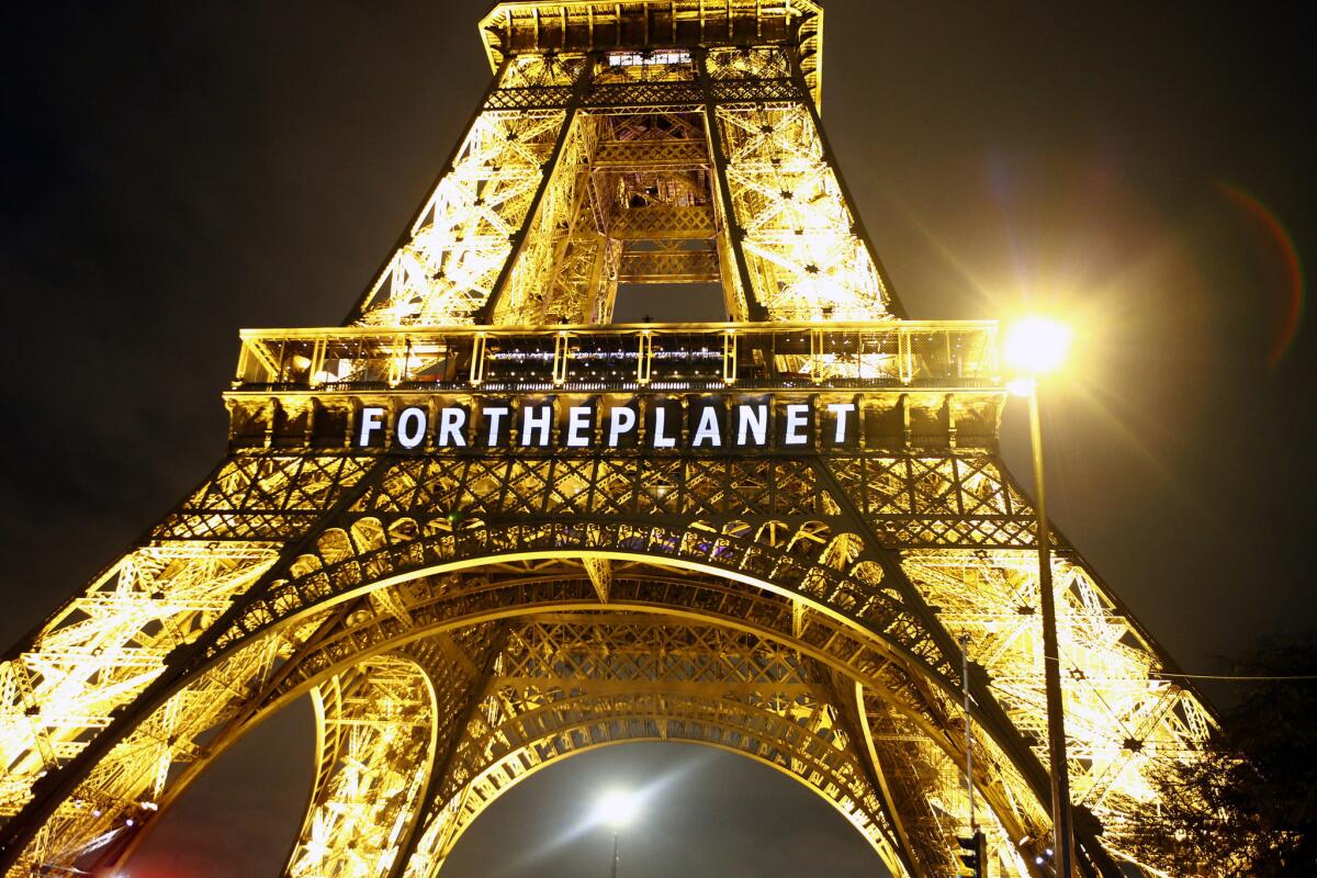 The slogan "FOR THE PLANET" is projected on the Eiffel Tower as part of United Nations Climate Change Conference on Dec. 11, 2015.