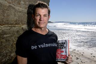 SOLANA BEACH, CA - JANUARY 09, 2024: Author Dustin Dunbar holds the book he wrote "You're Doing Great! And Other Lies Alcohol Told Me", while on the beach in Solana Beach on Tuesday, January 09, 2024.