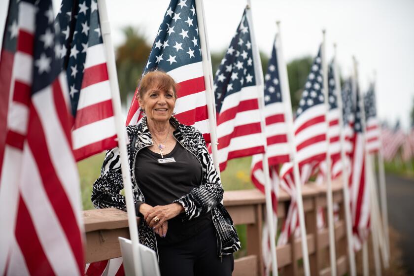 Lauretta Stansfield of the Exchange Club of Newport Beach poses for a photo while setting up the Field of Honor at Castaways Park in Newport Beach Friday, May 17.