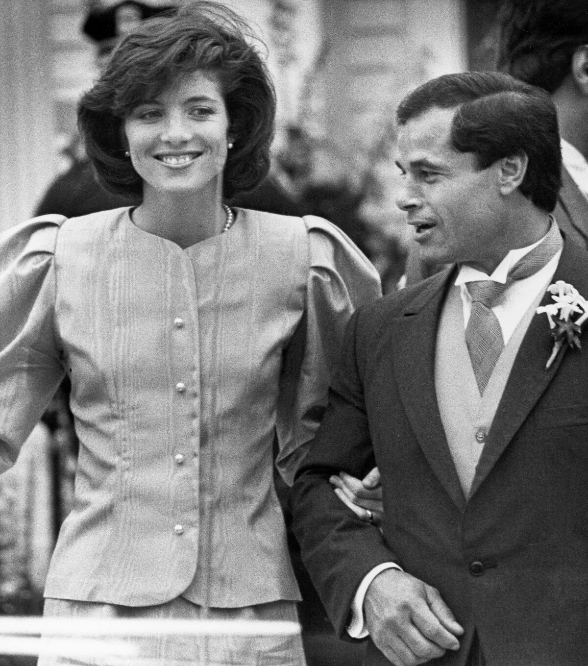 Caroline Kennedy and best man Franco Columbu leave St. Francis Xavier Church after the wedding of Caroline's cousin Maria Shriver to Arnold Schwarzenegger in Hyannis, Mass., in 1986.