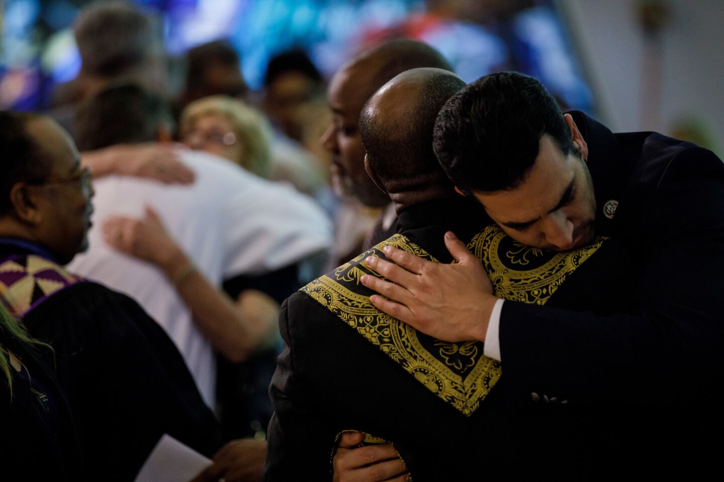 Rep. Ruben Kihuen (D-Nev.) hugs clergy members as they lead the Guardian Angel Cathedral congregation for a prayer event to honor the victims of the mass shooting.