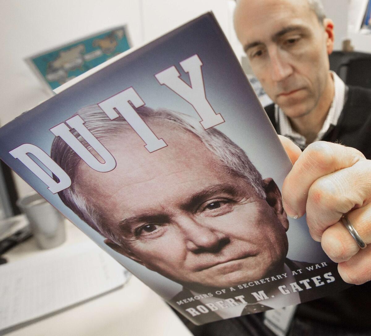 A journalist reads an advance copy of former U.S. Secretary of Defense Robert M. Gates' book, "Duty: Memoirs Of A Secretary At War," that is circulating among reporters in Washington, D.C.