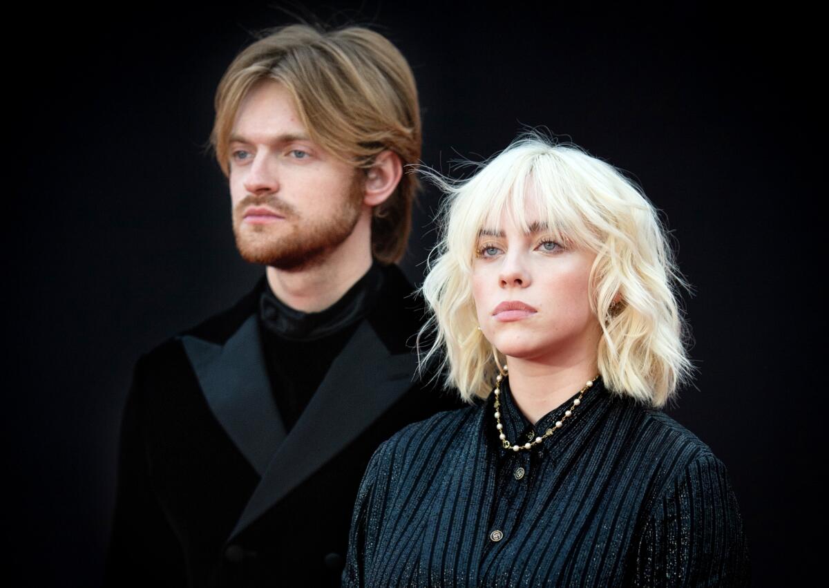 Billie Eilish and her brother in black clothing at a movie premiere