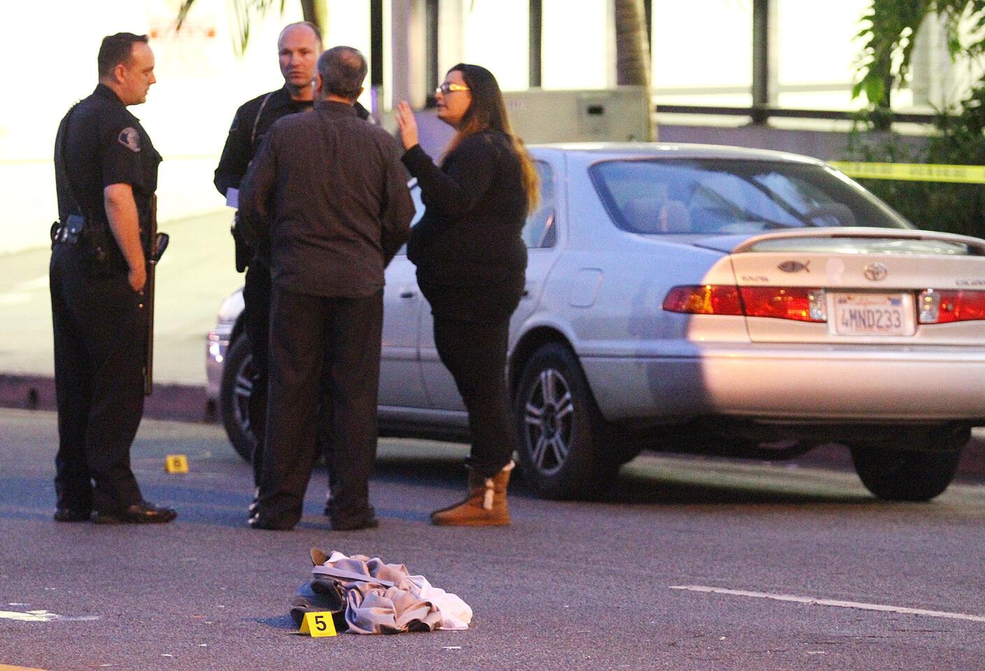 Glendale police officers question a man and a woman next to the alleged car at the scene where a pedestrian was hit by a motorist on the corner of Glenoaks Blvd. and Western Avenue in Glendale on Monday, January 27, 2014. The pedestrian was taken to the hospital with severe head injuries. (Tim Berger/Staff Photographer)