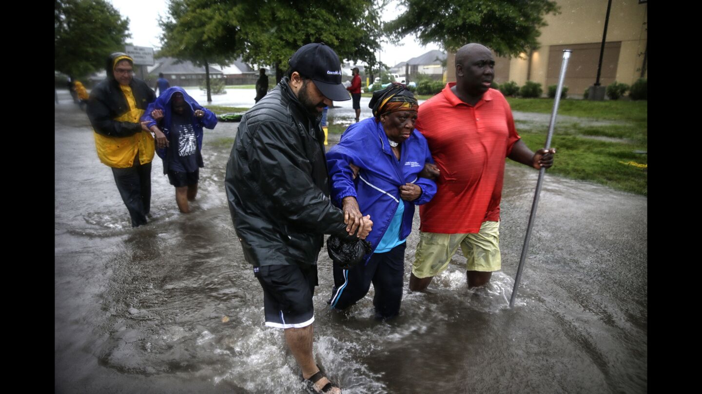 Comfort Morgan is helped to dry land after being rescued from her flooded home in Twin Oaks Village in Clodine.