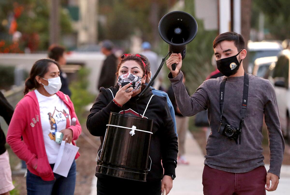 Activist Idalia Rios speaks on a bullhorn during a Tenants United Santa Ana rent control demonstration.