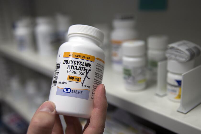 FILE - A pharmacist holds a bottle of the antibiotic doxycycline hyclate in Sacramento, Calif., July 8, 2016. U.S. health officials plan to endorse the antibiotic as a post-sex morning after pill that gay and bisexual men can use to avoid some increasingly common sexually transmitted diseases. The long-awaited guideline says doxycycline can prevent certain illnesses if taken within 72 hours of unprotected sex. One official says it's an innovative step to help battle record levels of STD infections. The Centers for Disease Control and Prevention proposal was released Monday, Oct. 2, 2023. (AP Photo/Rich Pedroncelli, File)