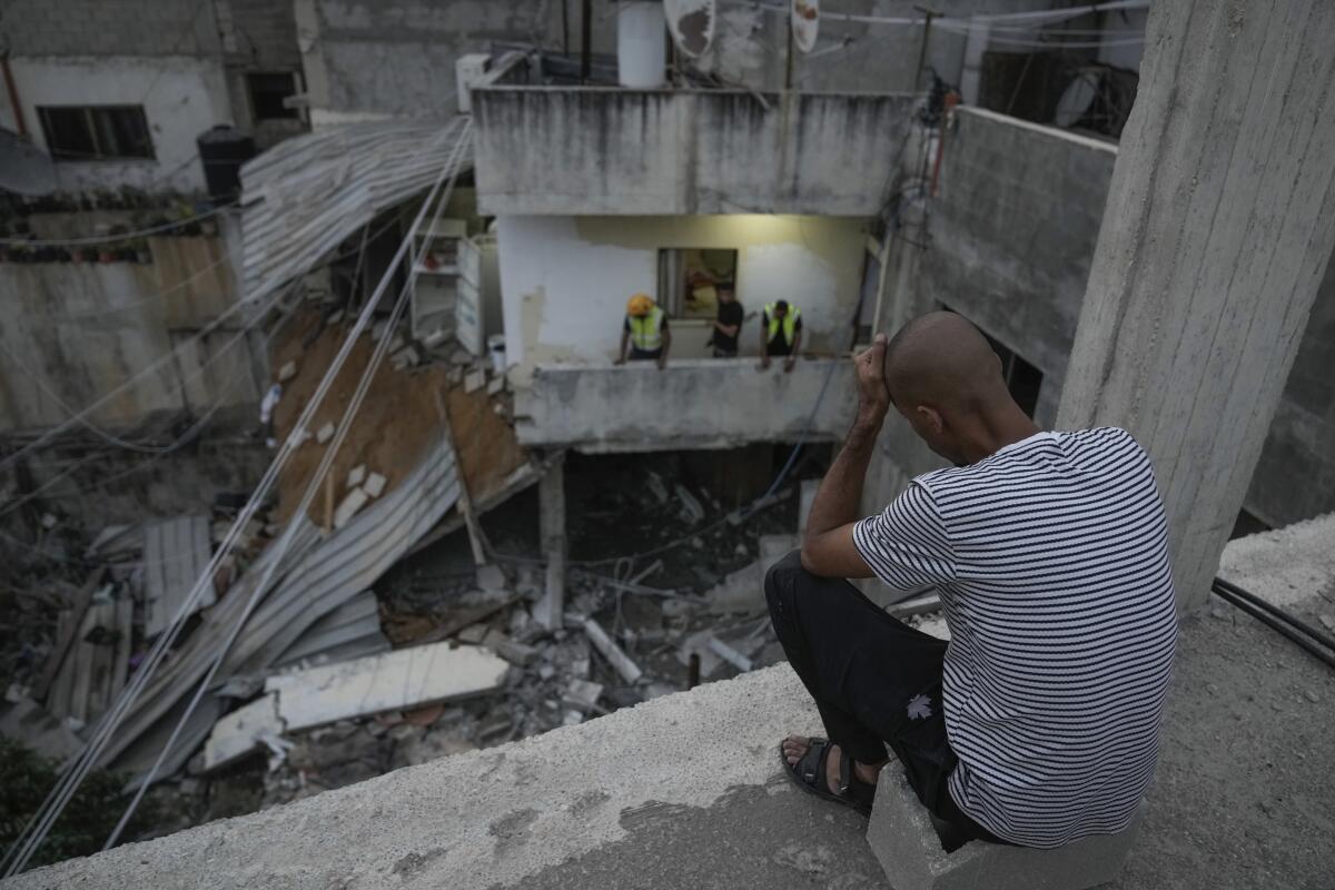 Palestinians inspect a badly damaged building following an Israeli army raid in a refugee camp in the northern West Bank 