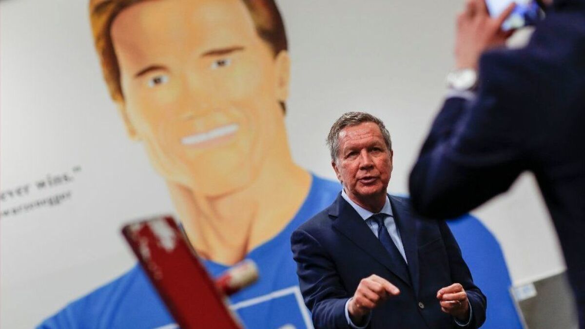 With a mural of former California Gov. Arnold Schwarzenegger as a backdrop, Ohio Gov. John Kasich records a message after the event.