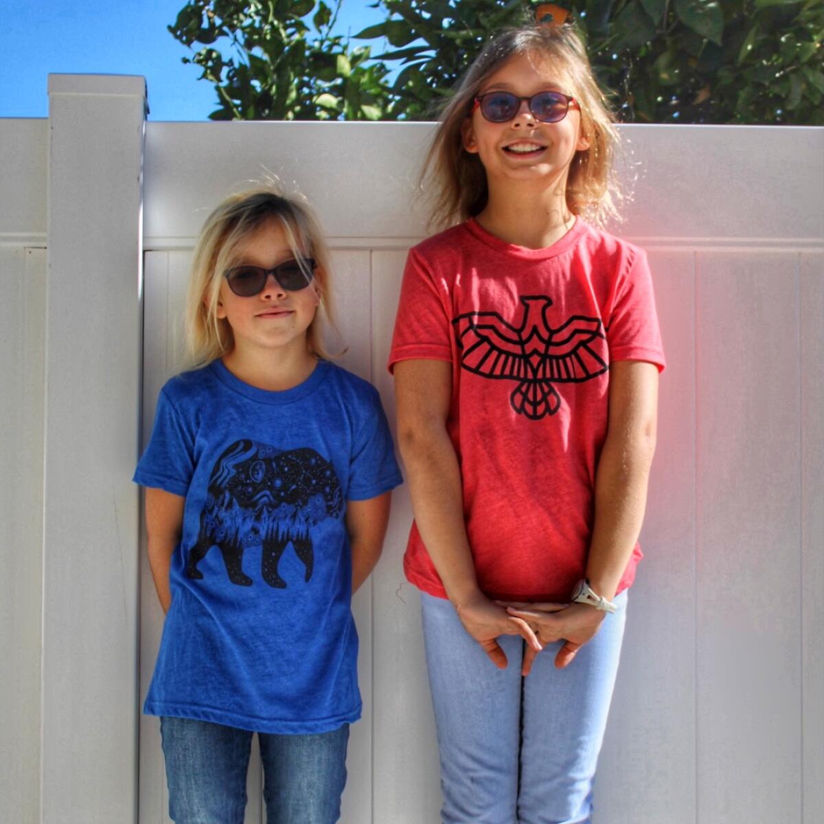 Sahara and Maya Wells show off their Never Stop Discovering t-shirts.