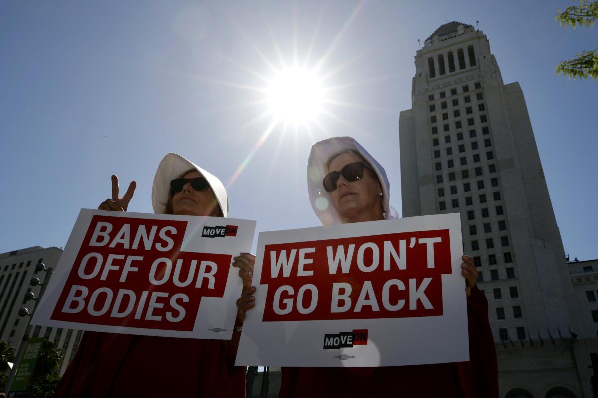 Protesters hold signs before an abortion rights rally in downtown Los Angeles on May 14. 