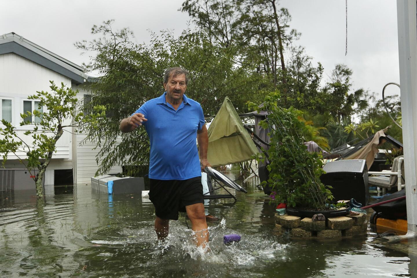 John Krowzow, 74, wades in floodwater to check out his homes in Corkscrew Woodlands, a park with 640