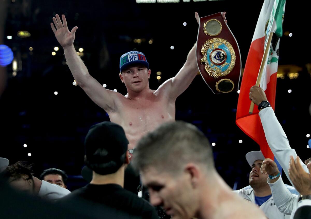Canelo Alvarez celebrates after knocking out Liam Smith, lower middle, during their WBO junior-middleweight bout at AT&T Stadium in Arlington, Texas, on Sept. 17, 2016.