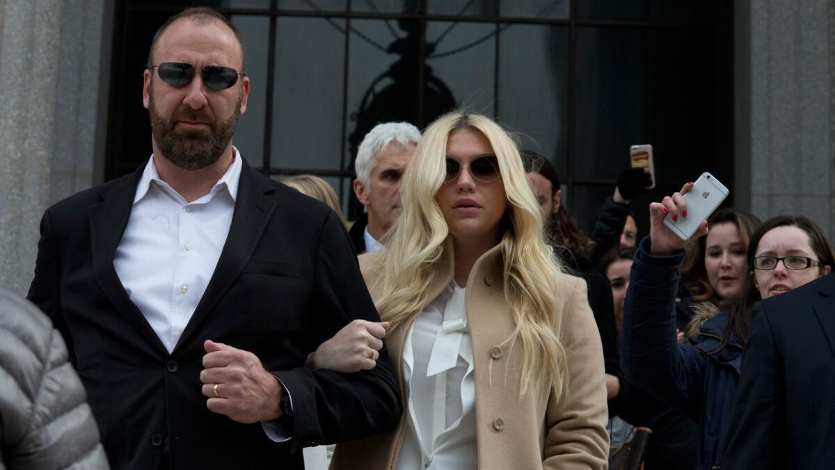 Pop star Kesha, center, leaves court in New York on Friday.