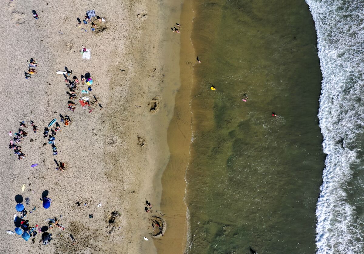 An aerial view of beachgoers enjoying a warm, sunny Saturday in Newport Beach.