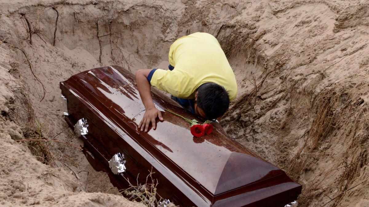 A son of Mexican journalist Carlos Dominguez, killed on Jan. 13 in the state of Tamaulipas, mourns over his coffin during his funeral in Guerrero state. Dominguez was the first journalist killed in Mexico in 2018.