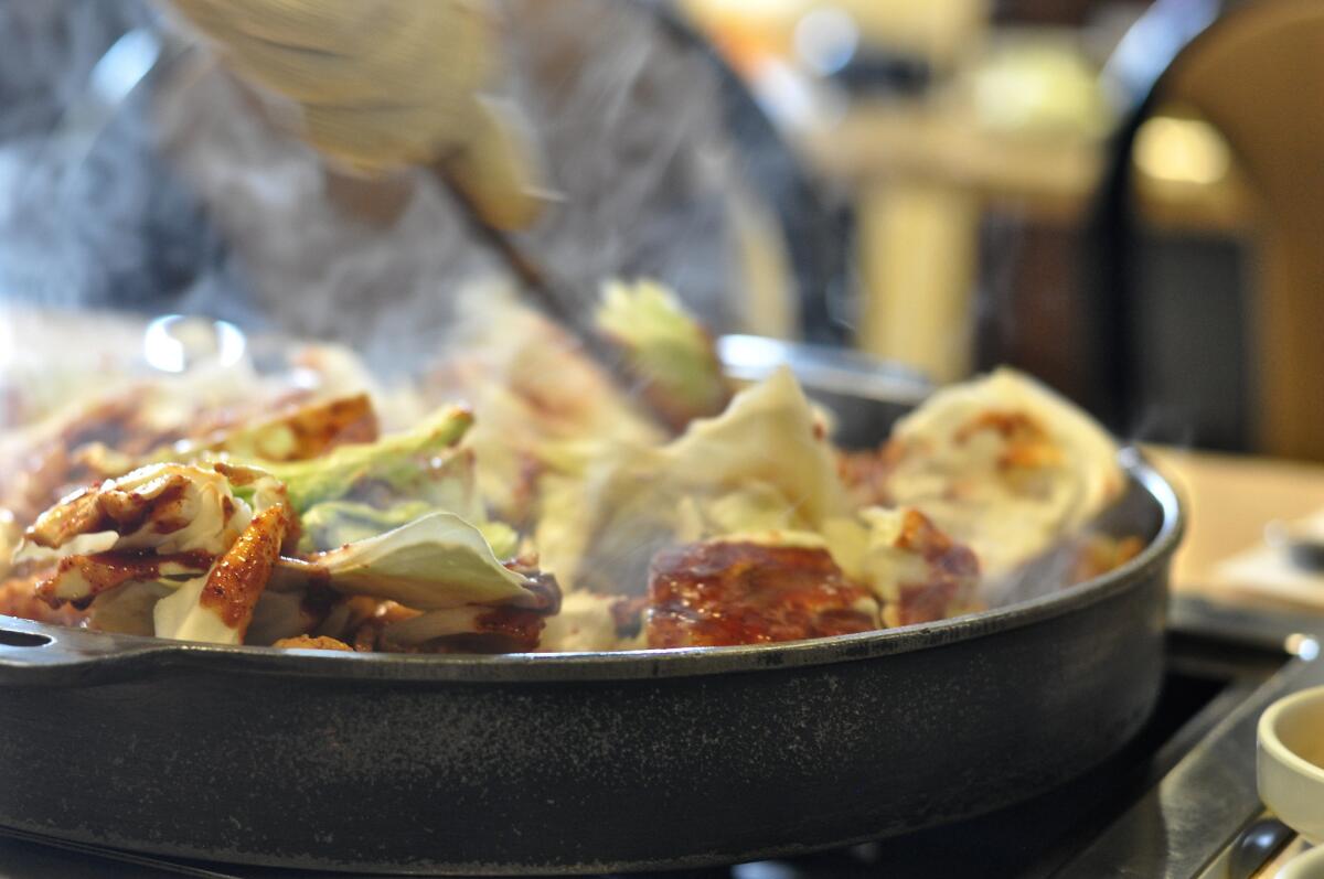 Cabbage and hot sauce are srirred into the Chicken Galbi dish.