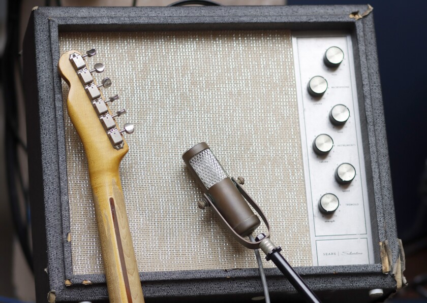 A Fender Telecaster and microphone sit against a vintage Sears Silvertone amplifier.
