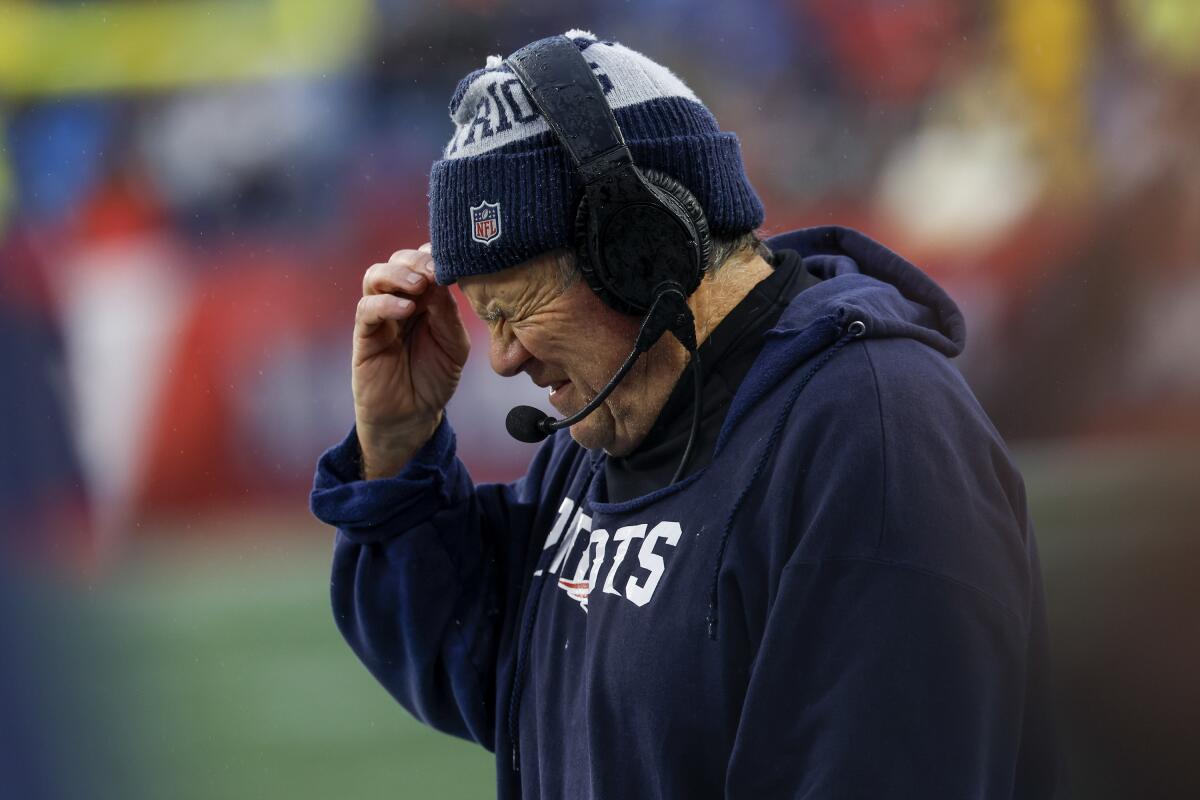 New England Patriots coach Bill Belichick closes his eyes and holds his hand to his head.