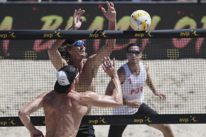 HERMOSA BEACH, CA, SATURDAY, JULY 27, 2019 - David Lee knocks the ball past Ed Ratledge during first set action of an elimination round game at the AVP Hermosa Beach Open at Hermosa Beach. (Robert Gauthier/Los Angeles Times)