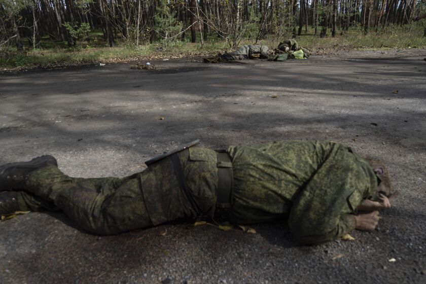 Cuerpos de militares rusos muertos se ven en el suelo en la ciudad de Lyman, recién recuperada por fuerzas ucranianas, en Lyman, Ucrania, el lunes 3 de octubre de 2022. (AP foto/Evgeniy Maloletka)