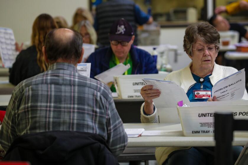 Santa Ana, CA - November 09: Christine Cheney, right, checks ballots at Vote-By-Mail ballot processing center at Orange County Registrar of Voters on Wednesday, Nov. 9, 2022 in Santa Ana, CA. (Irfan Khan / Los Angeles Times)