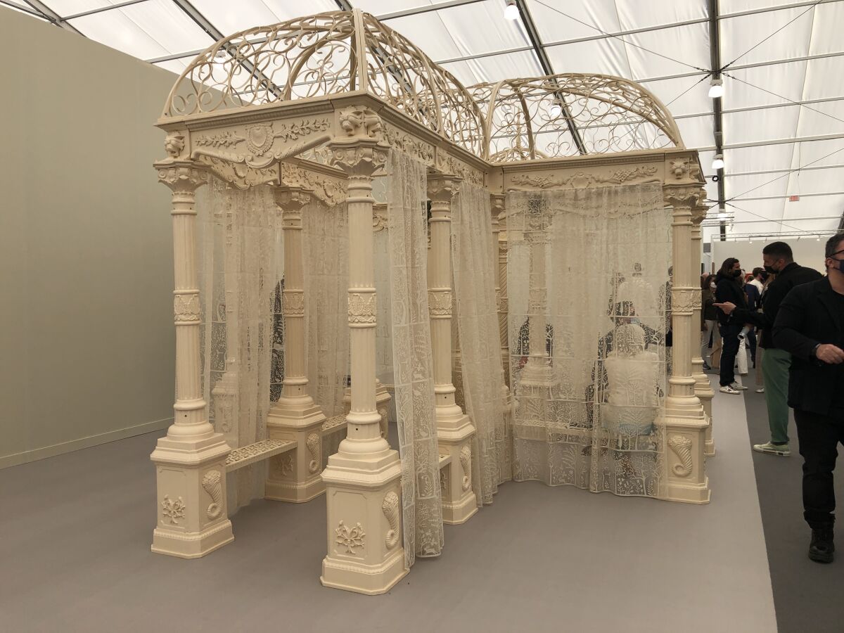A view of a series of conjoined gazebos lined with lace curtains.